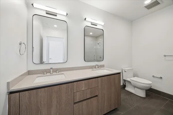 a bathroom with double sink and a mirror