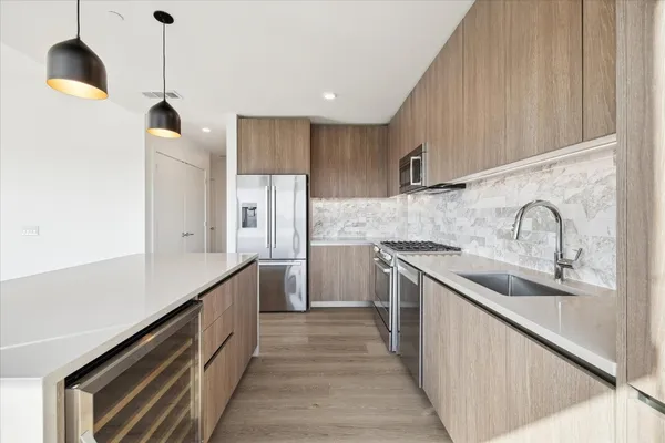 a kitchen with stainless steel appliances granite countertop a sink and a refrigerator