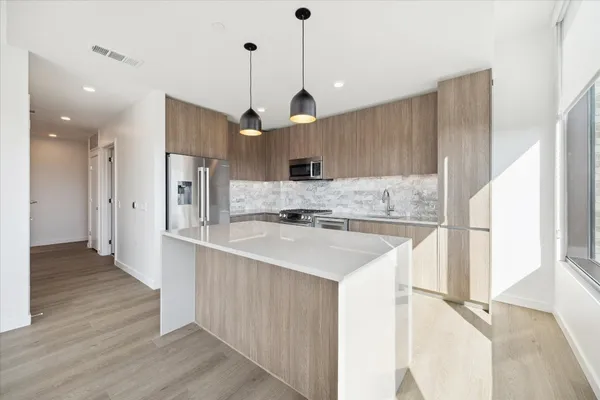 a kitchen with kitchen island a sink stainless steel appliances and cabinets