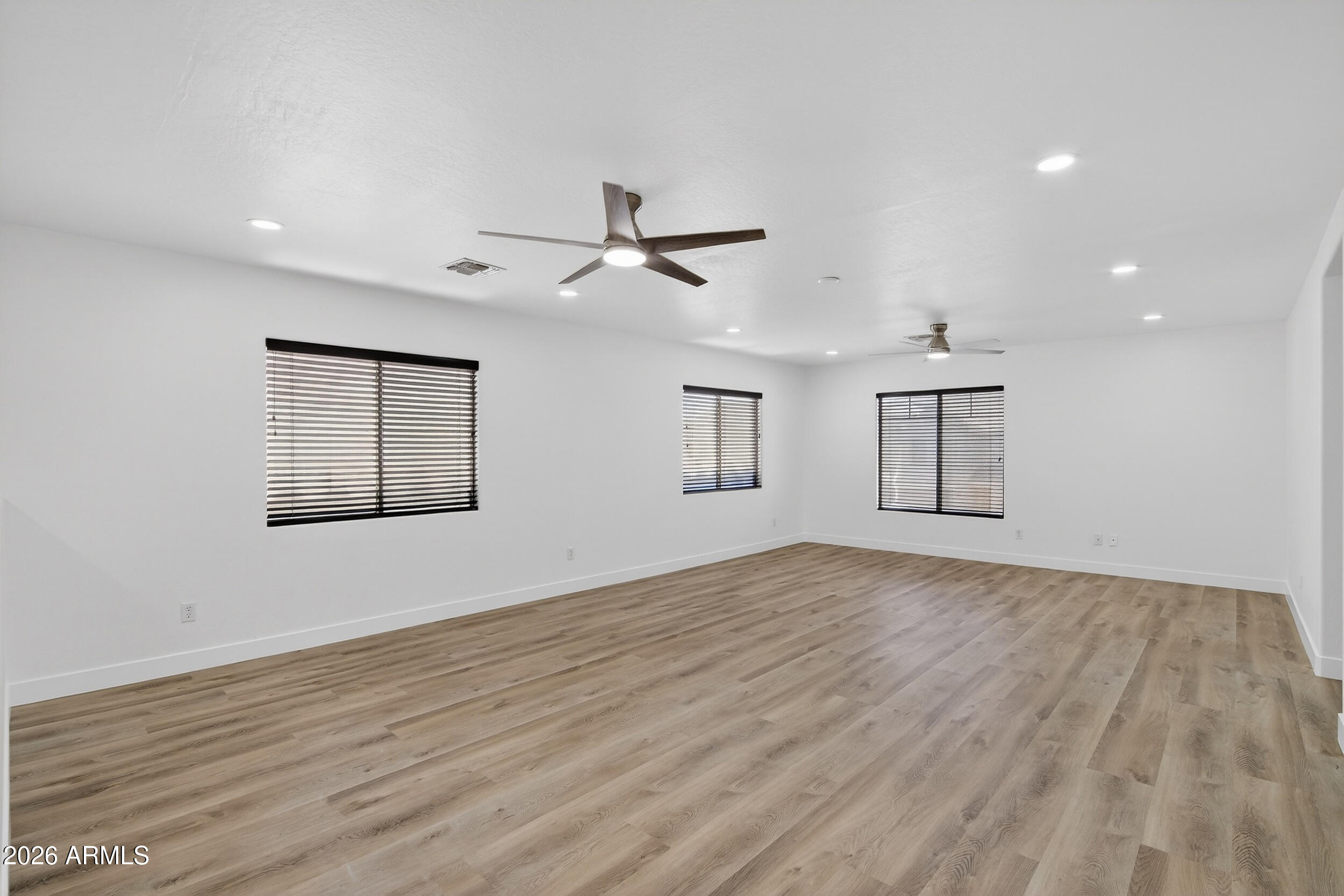 43620 West Cowpath Road Maricopa, AZ 85138 - Photo 25 of 60 a view of empty room with wooden floor and fan
