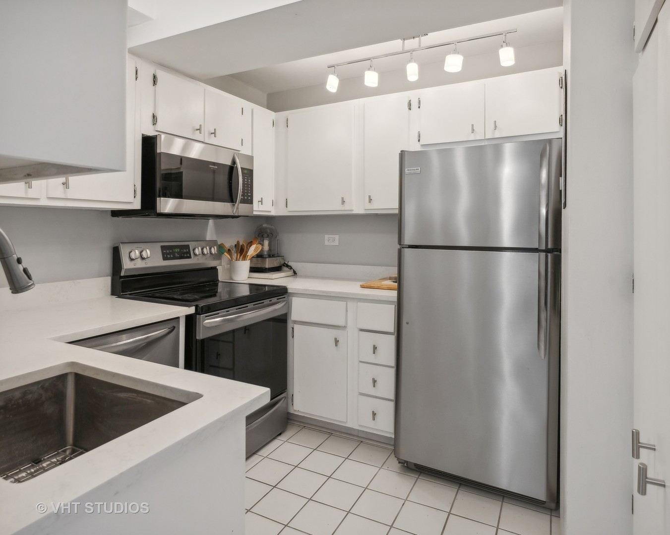 2909 North Sheridan Road, Unit 609 Chicago, IL 60657 - Photo 5 of 11 a kitchen with white cabinets and white appliances