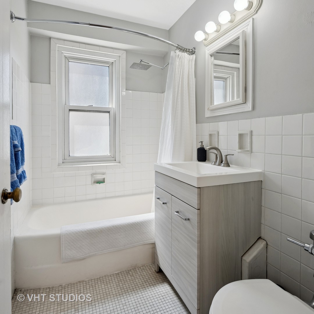 2909 North Sheridan Road, Unit 609 Chicago, IL 60657 - Photo 8 of 11 a bathroom with a sink toilet vanity and tub