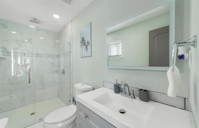 a bathroom with a sink a toilet and shower