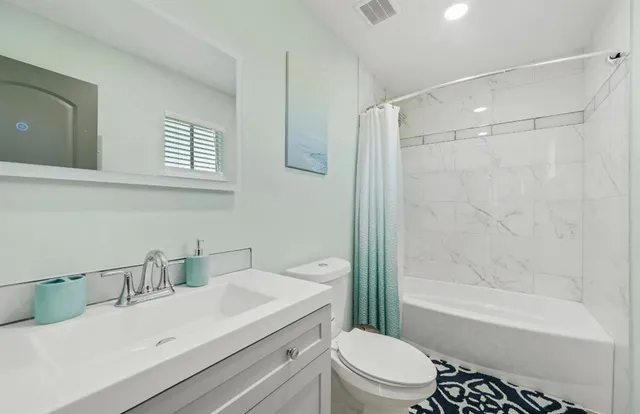a bathroom with a sink toilet vanity and shower