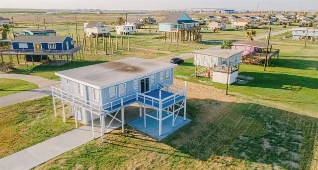 an aerial view of residential houses with outdoor space and ocean view