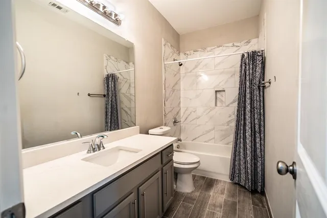 a bathroom with a granite countertop sink toilet and shower