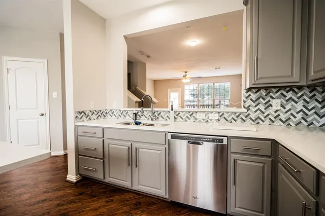 a kitchen with stainless steel appliances granite countertop a sink and cabinets with wooden floor