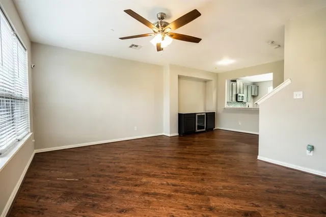 an empty room with wooden floor and a ceiling fan