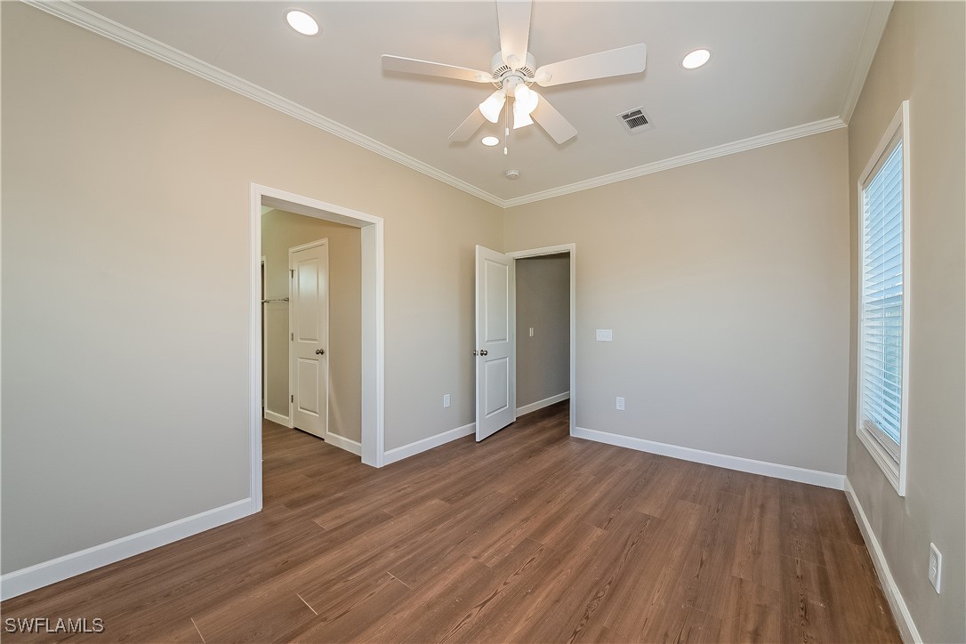 217 Santurce Avenue North Port, FL 34287 - Photo 11 of 16 an empty room with wooden floor and a ceiling fan