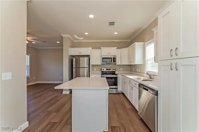 a kitchen with refrigerator cabinets and wooden floor