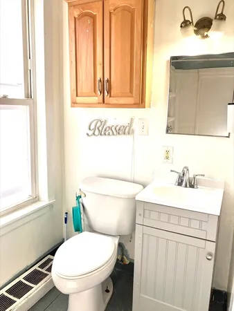 a bathroom with a sink a toilet and a mirror