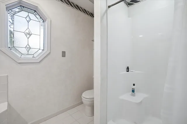 a bathroom with a toilet and a shower