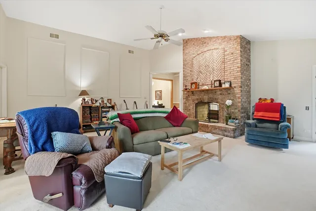 a living room with furniture fireplace and a large window