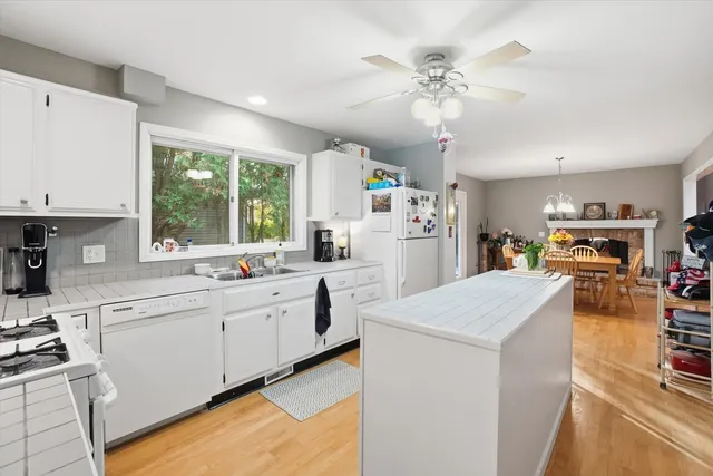 a open kitchen with cabinets a stove and a chandelier