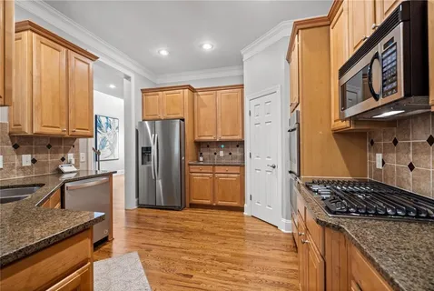 a kitchen with stainless steel appliances granite countertop a refrigerator and a stove top oven