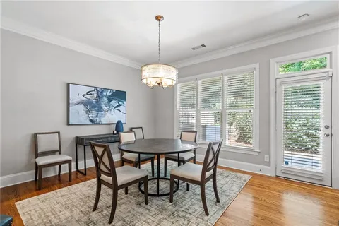 a dining room with furniture a chandelier and wooden floor