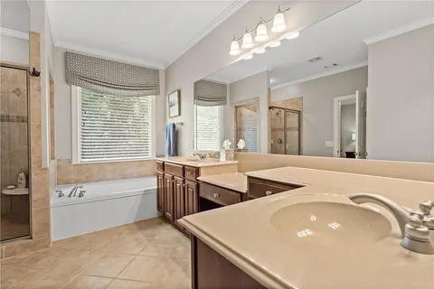 a spacious bathroom with a granite countertop sink and a bathtub
