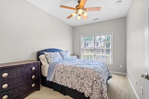 a bedroom with a bed a dresser and a window