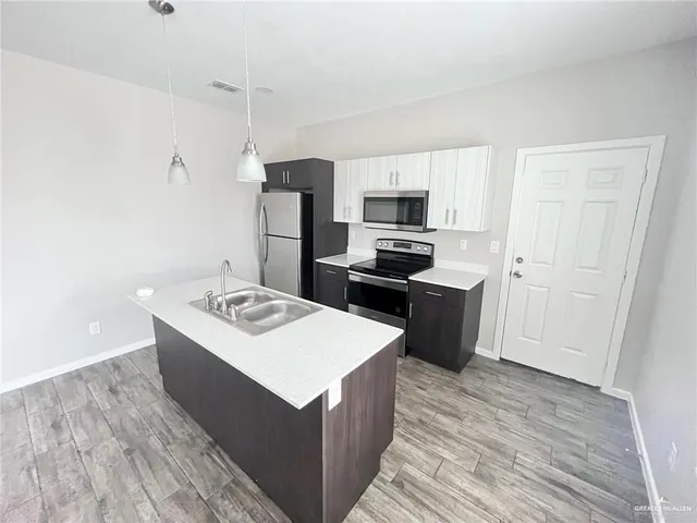 a kitchen with a sink a stove a refrigerator and a microwave