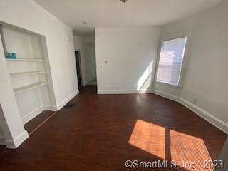 210 Coleman Street, Unit 1 Bridgeport, CT 06604 - Photo 2 of 8 an empty room with wooden floor and windows