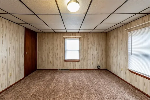 a view of a big house with a big yard and large trees