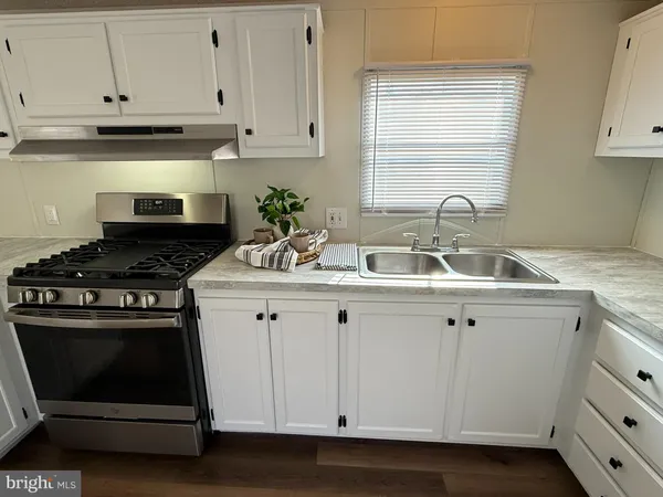 a kitchen with granite countertop white cabinets and white appliances