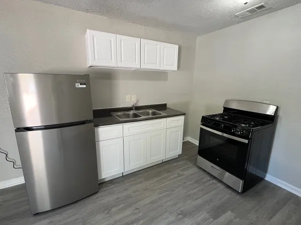 a kitchen with a refrigerator stove and cabinets