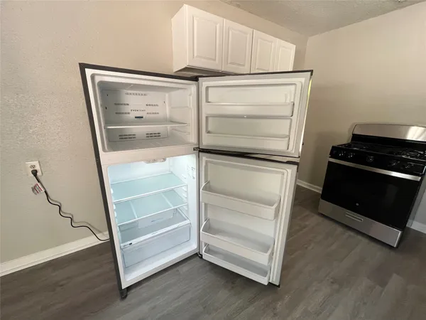 a walk in closet with wooden floor