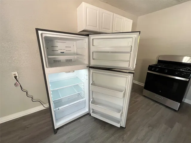 a walk in closet with wooden floor