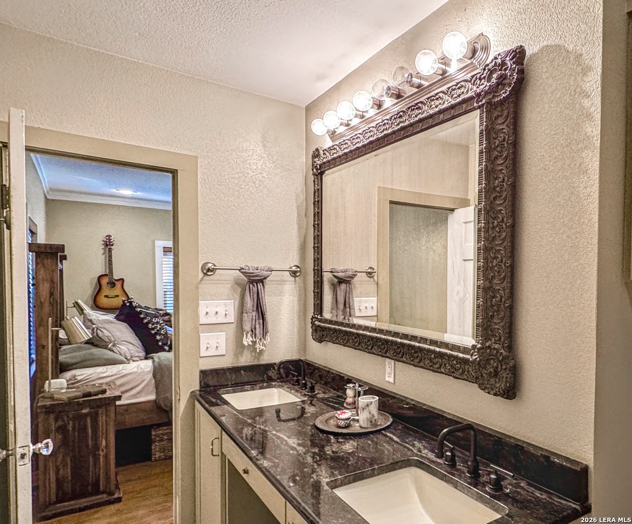 2828 2nd Street Pleasanton, TX 78064 - Photo 28 of 48 a bathroom with a granite countertop sink and a mirror