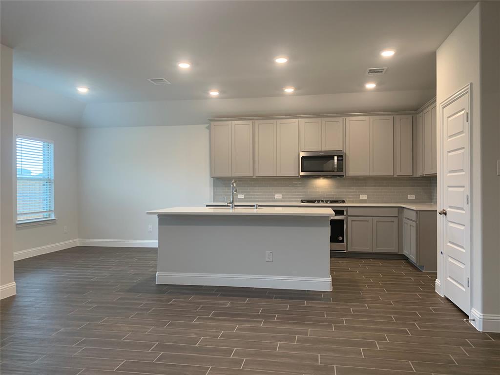 765 Knoxbridge Road Forney, TX 75126 - Photo 4 of 22 a kitchen with stainless steel appliances granite countertop a sink a stove a refrigerator and a microwave