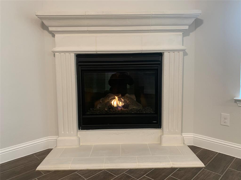 765 Knoxbridge Road Forney, TX 75126 - Photo 9 of 22 a living room with a fireplace and a wooden floor