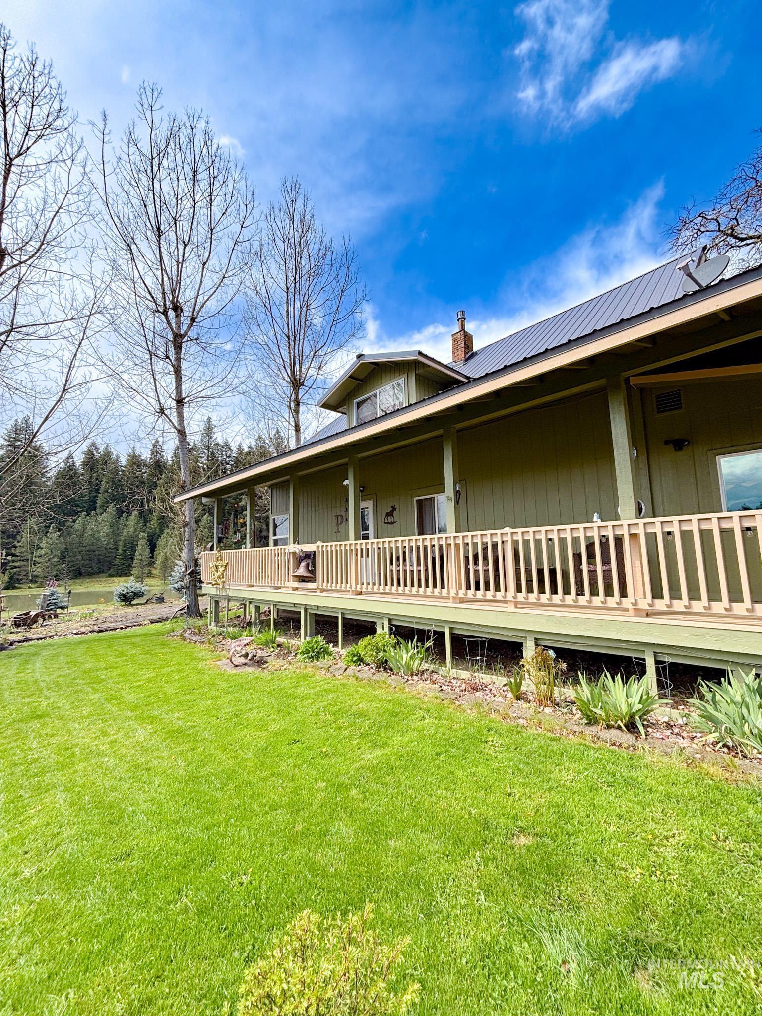 1995 Glenwood Road Kamiah, ID 83536 - Photo 2 of 38 Expansive green lawn bordering a wrap-around porch with a light wood railing