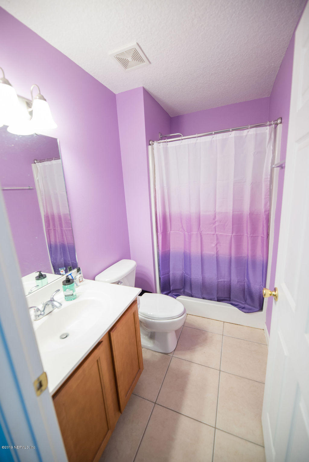 9171 Raptor Drive Jacksonville, FL 32221 - Photo 10 of 13 a bathroom with a sink a toilet and shower curtain