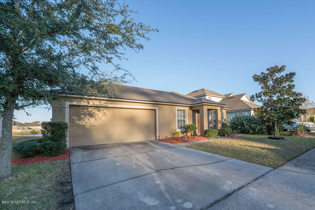 9171 Raptor Drive Jacksonville, FL 32221 - Photo 2 of 13 a front view of a house with a yard and a garage