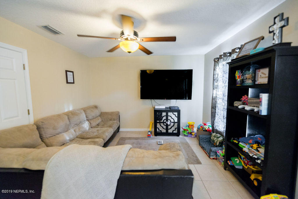 9171 Raptor Drive Jacksonville, FL 32221 - Photo 5 of 13 a living room with furniture and a flat screen tv