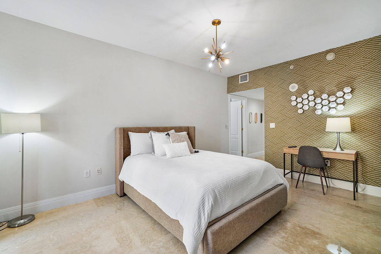 200 East Palmetto Park Road, Unit 410 Boca Raton, FL 33432 - Photo 16 of 44 a bedroom with a bed and a chandelier