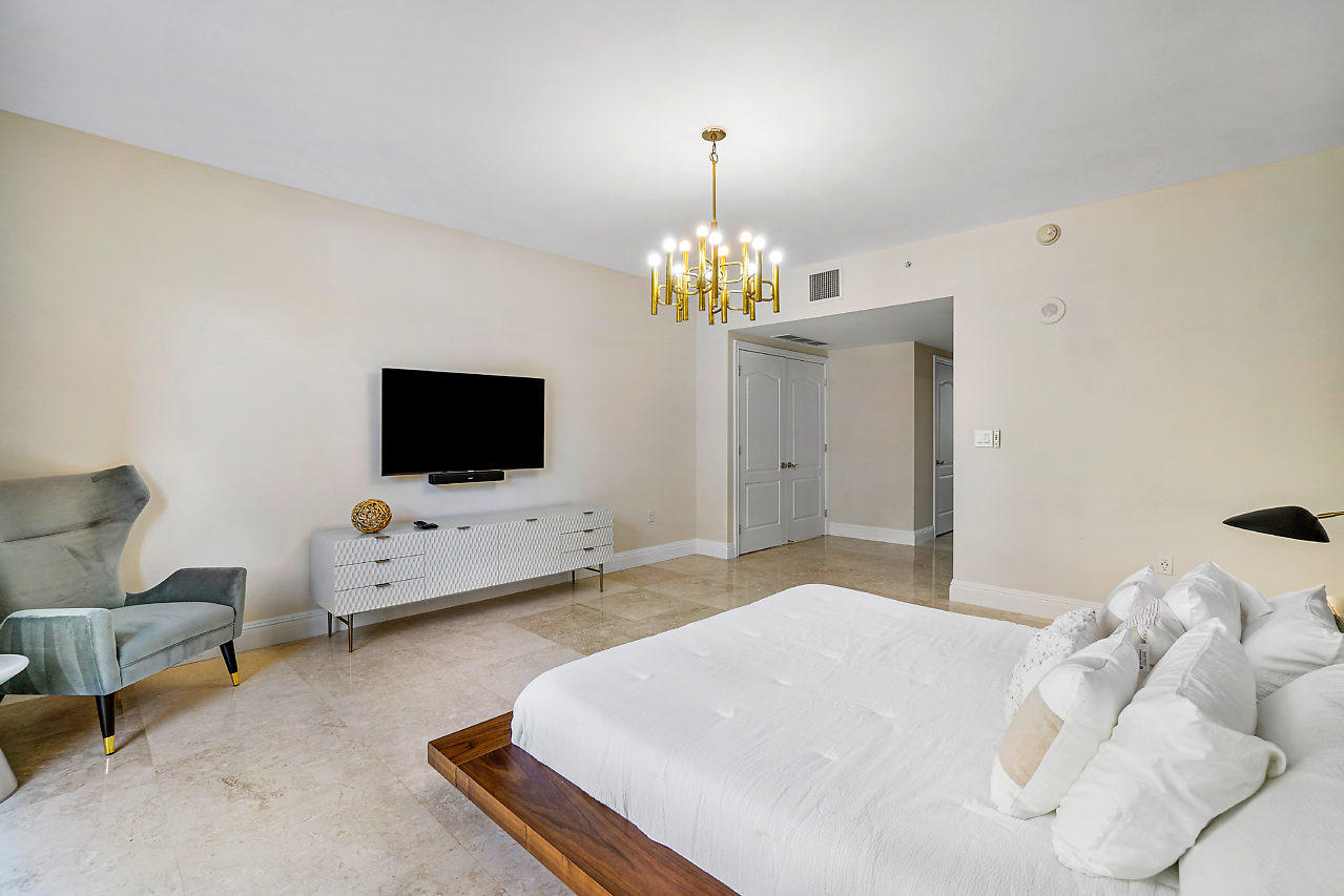 200 East Palmetto Park Road, Unit 410 Boca Raton, FL 33432 - Photo 21 of 44 a spacious bedroom with a bed and a flat screen tv
