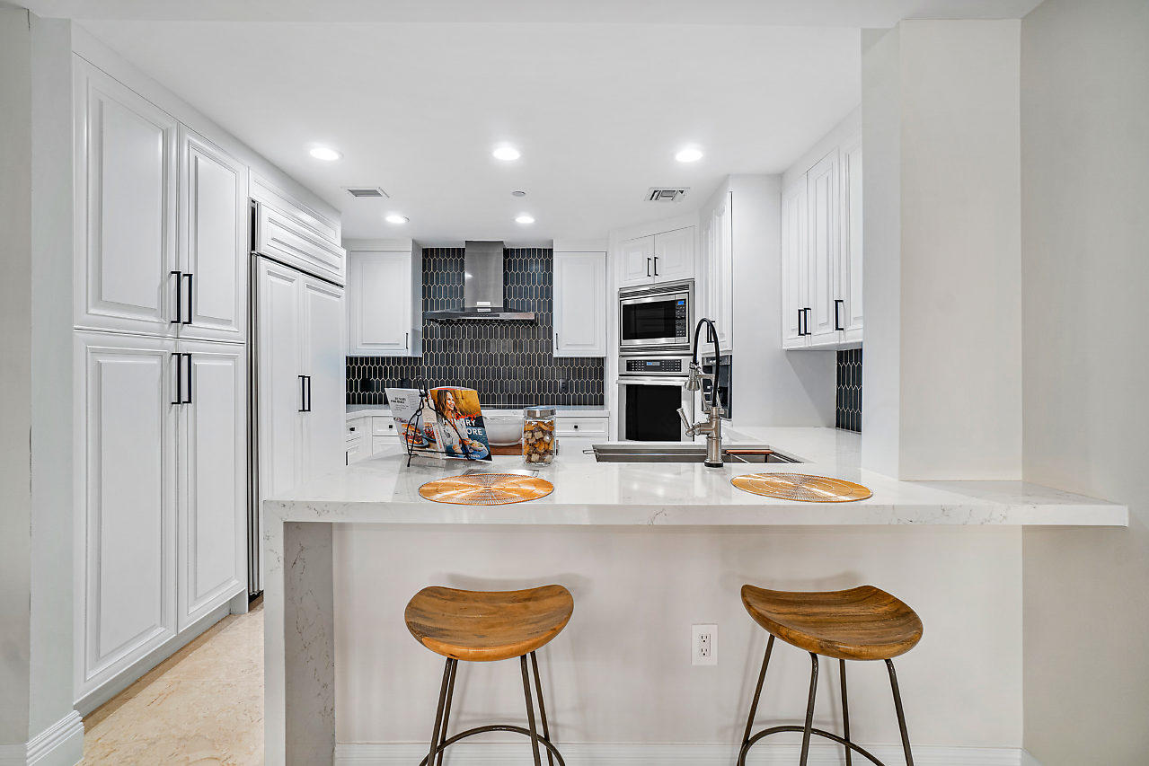 200 East Palmetto Park Road, Unit 410 Boca Raton, FL 33432 - Photo 6 of 44 a kitchen with stainless steel appliances granite countertop a sink and a refrigerator