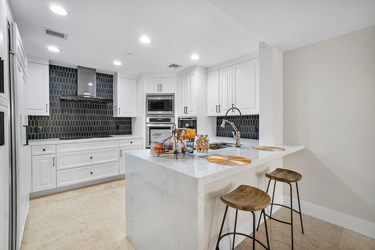 200 East Palmetto Park Road, Unit 410 Boca Raton, FL 33432 - Photo 10 of 44 a kitchen with white cabinets and stainless steel appliances