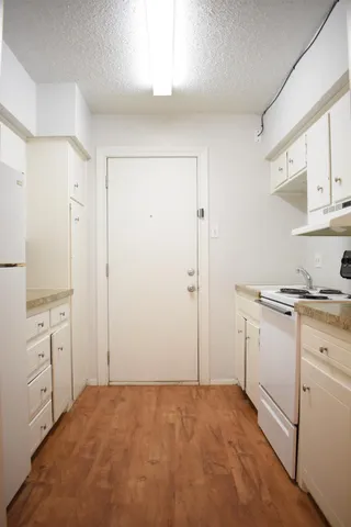 a view of a kitchen with white cabinets