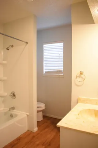 a bathroom with a granite countertop sink toilet and bathtub