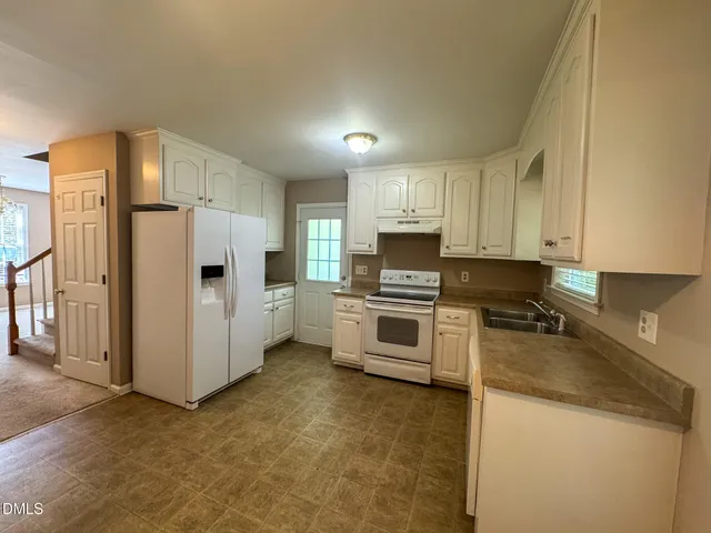 a kitchen with refrigerator a stove a microwave and cabinets