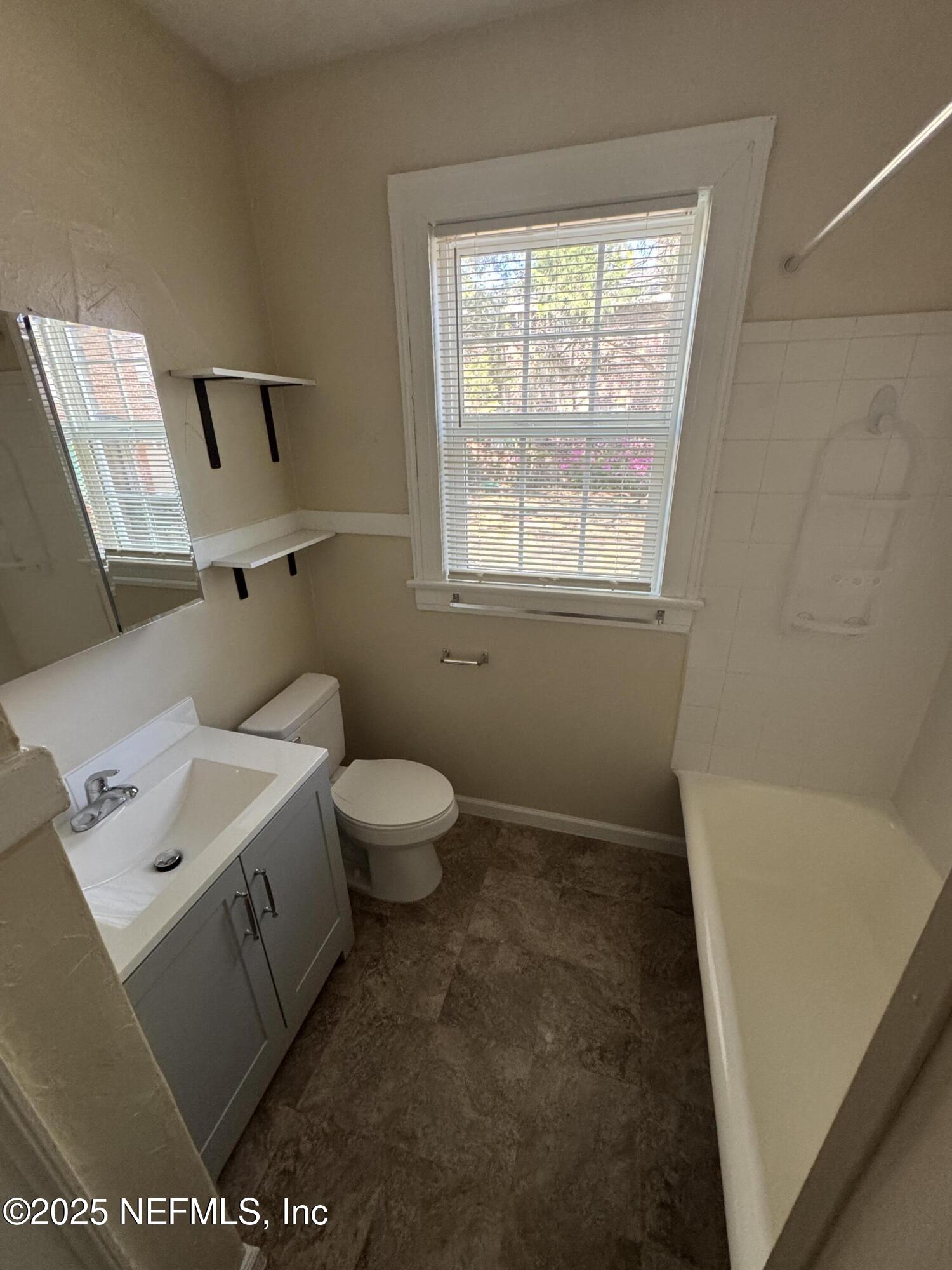 2056 Post Street, Unit 1 Jacksonville, FL 32204 - Photo 3 of 10 a bathroom with a toilet sink and mirror