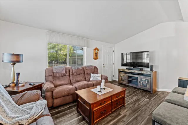 a living room with furniture a flat screen tv and a window