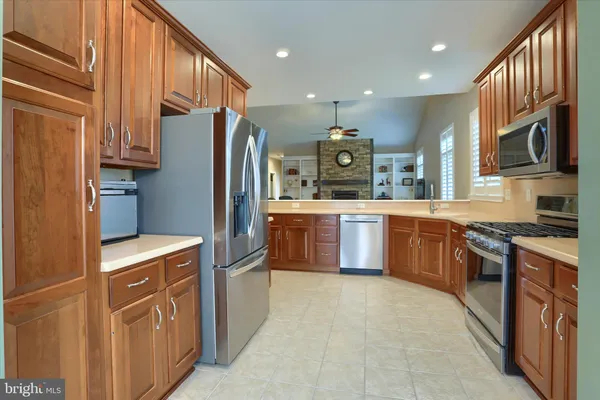 a kitchen with stainless steel appliances granite countertop a stove refrigerator and a sink