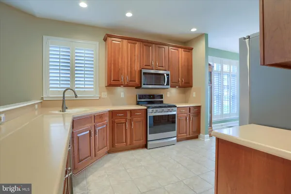 a kitchen with stainless steel appliances a stove sink microwave and cabinets