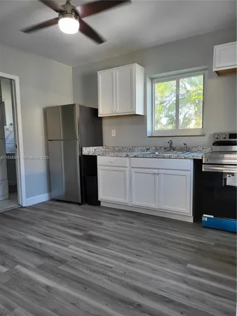 a kitchen with stainless steel appliances kitchen island granite countertop a stove a sink and a refrigerator