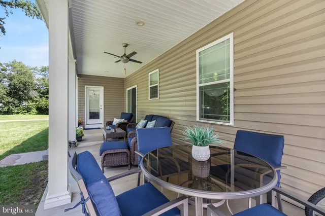 a view of a patio with couches table and chairs and potted plants