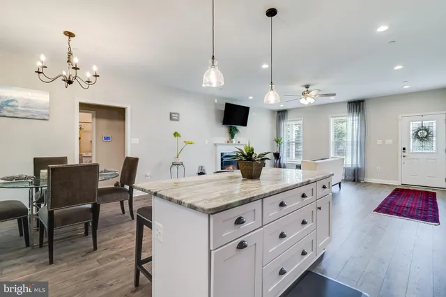 a large kitchen with kitchen island a dining table chairs and a chandelier